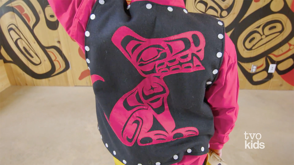 A close-up of Drakon wearing his regalia, which includes a vest with an animal on it.