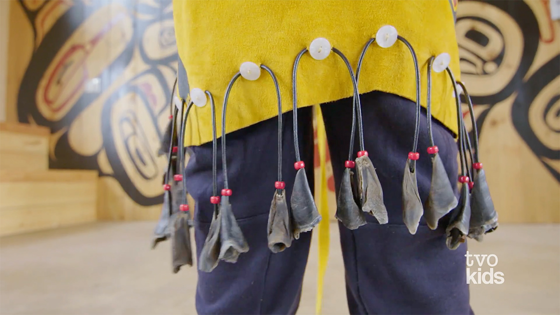 A close-up of Drakon wearing his regalia, which includes an apron with beads made of deer hooves.