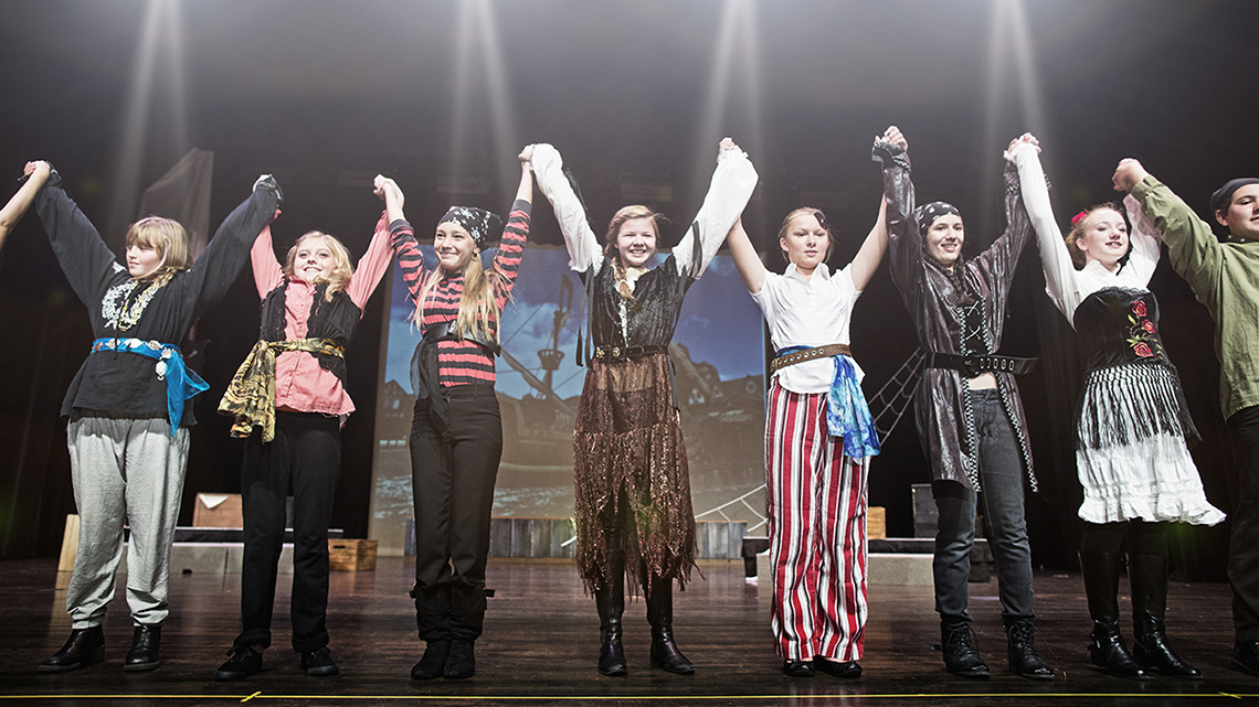A group of people are holding hands and bowing.