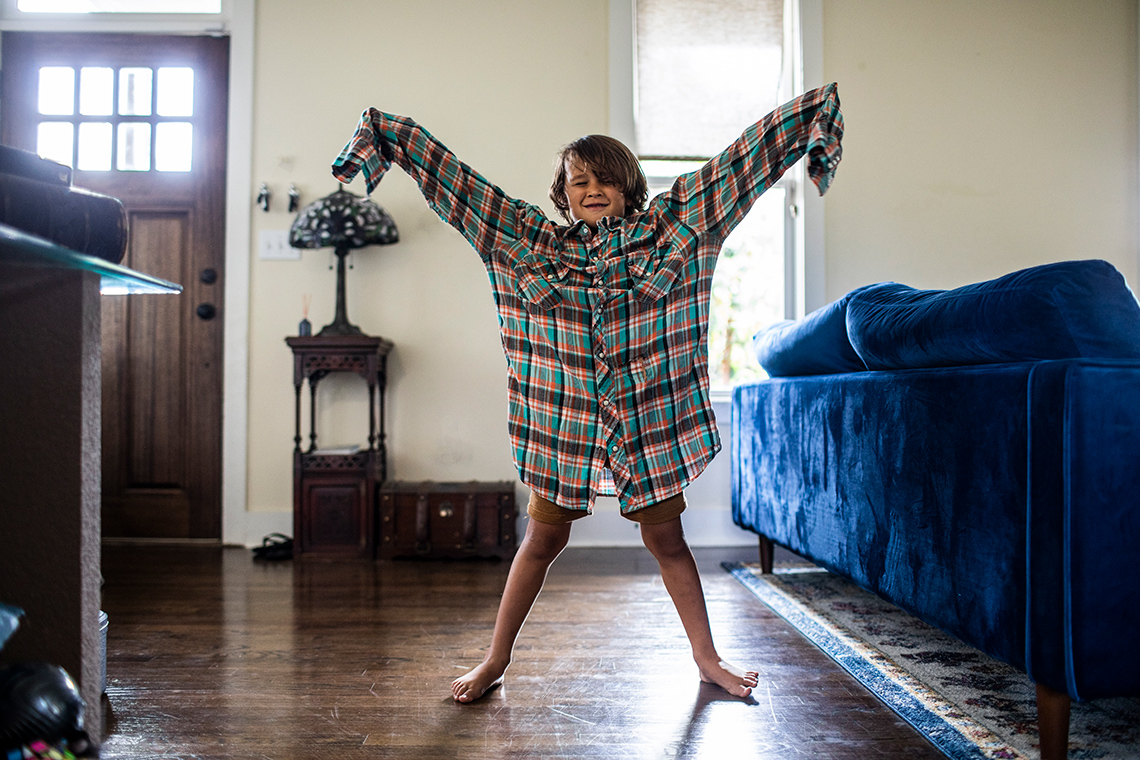 A person is standing with their legs and arms spread wide apart.