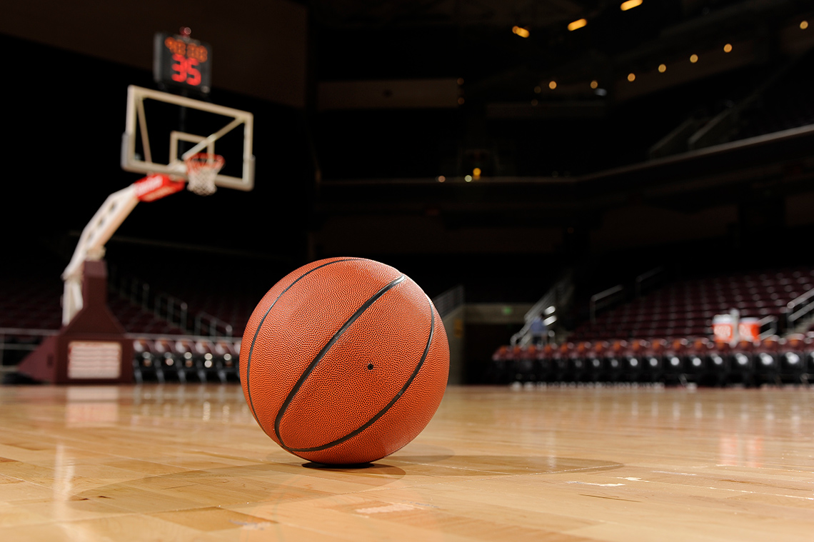 A basketball on the floor of a gymnasium<