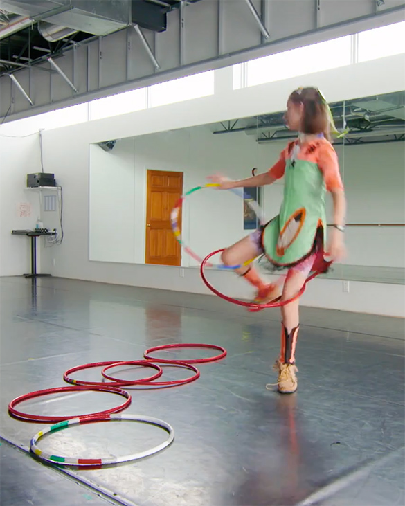 Emily dancing with two hoops around her leg and torso.