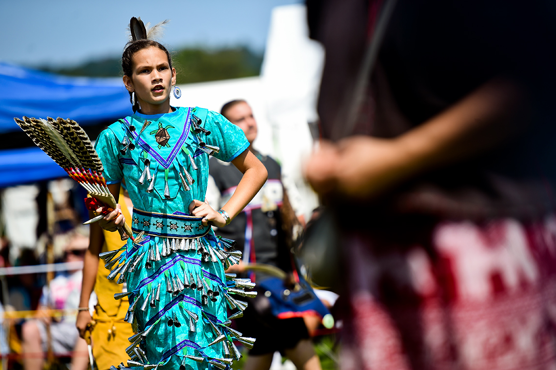 A dancer is dressed in a traditional Jingle Dress.