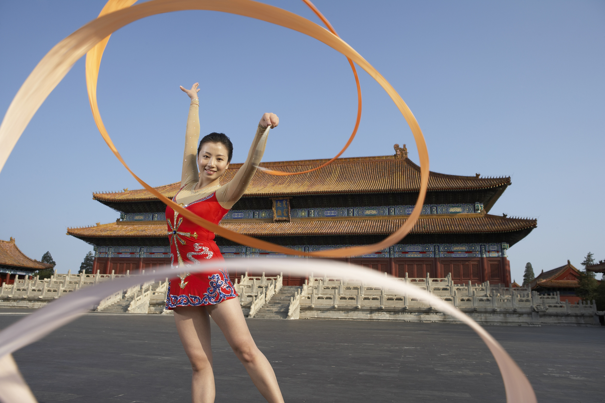 Individual performing Chinese Ribbon dance with a long ribbon.