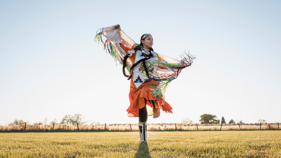 Indigenous dancer dressed in traditional regalia dancing.