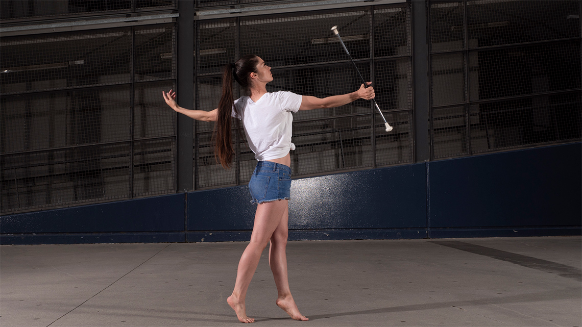 A dancer, holding a baton in their right hand.