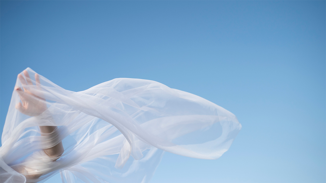 A white sheer fabric against a blue-sky background.