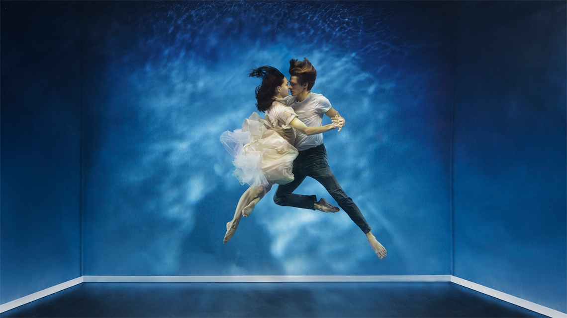 Two adults are facing each other while dancing together.