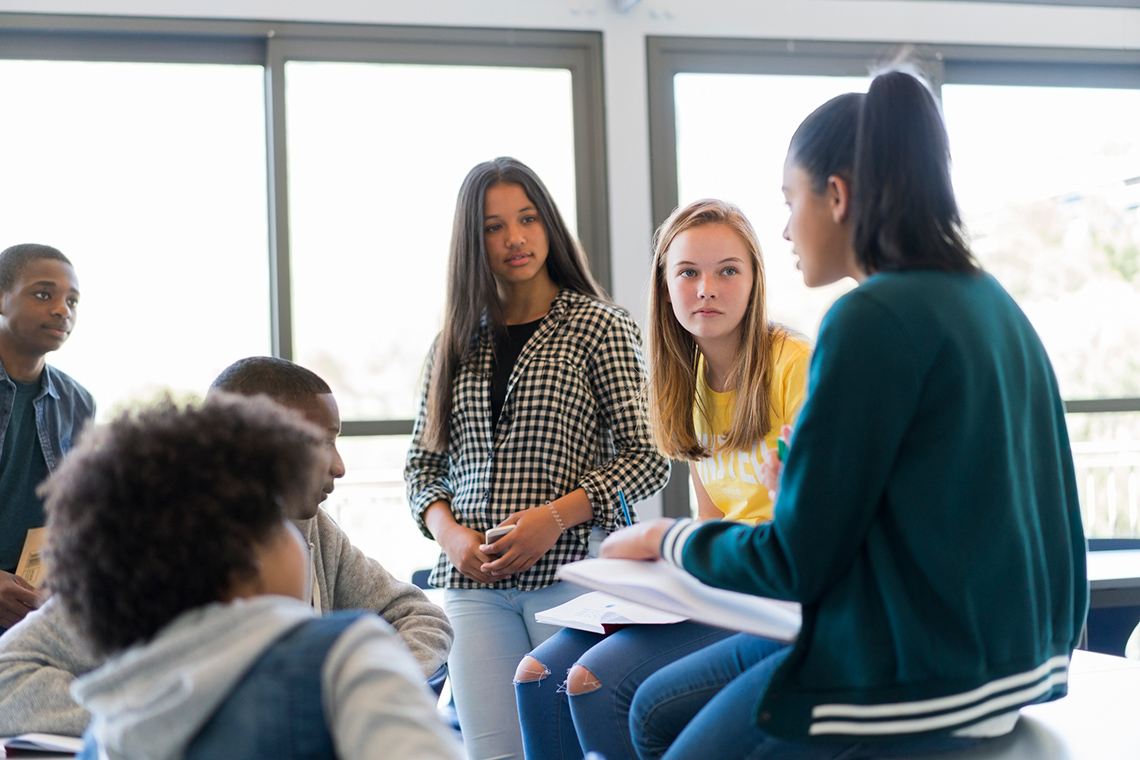 A group of students are having a discussion in a classroom.