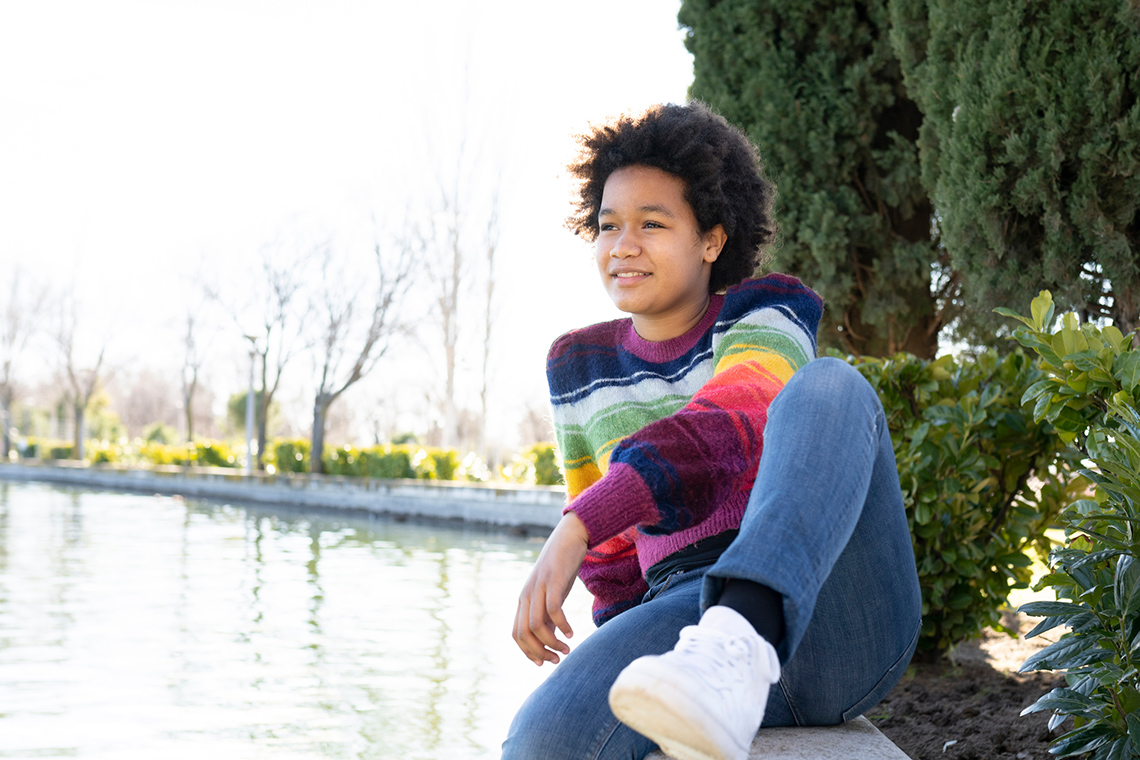 Student looking thoughtfully out over a pond