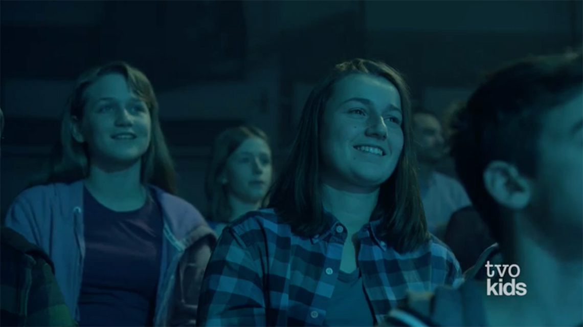 Audience members smiling at the performer.