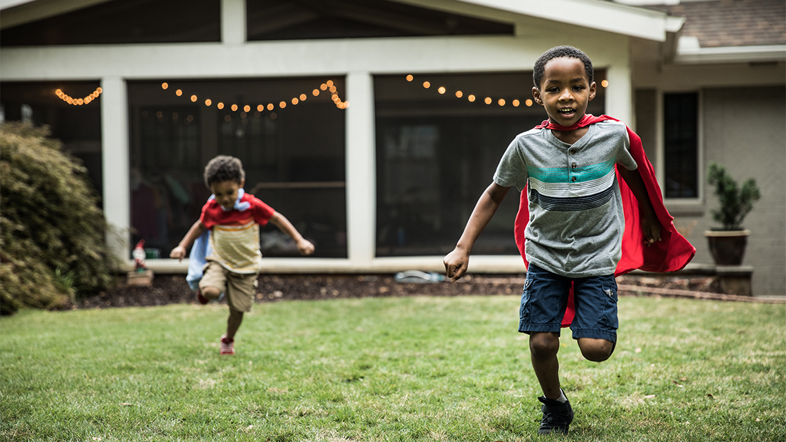 Children pretending to be superheroes with capes tied around their necks.