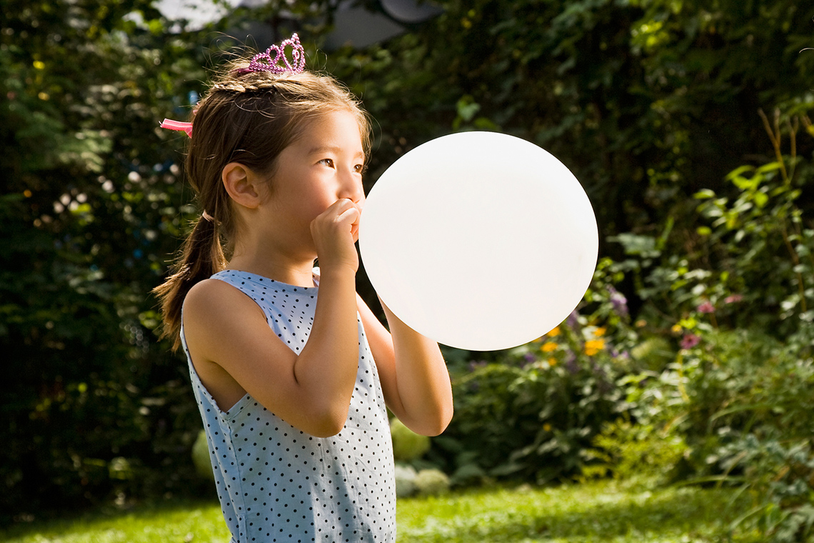 Child blowing a balloon