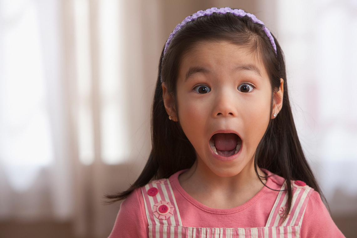A child with their mouth opened wide.