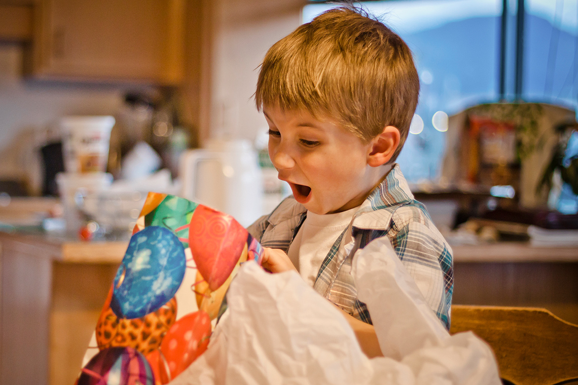 A very excited child opening a present.