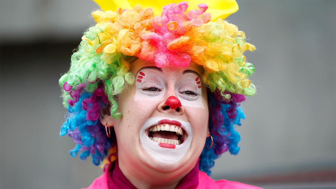 Person with a big smile wearing a clown costume.