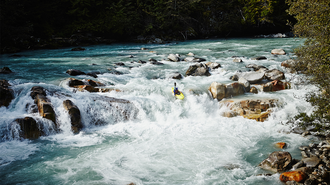 A person Kayaking down a river.