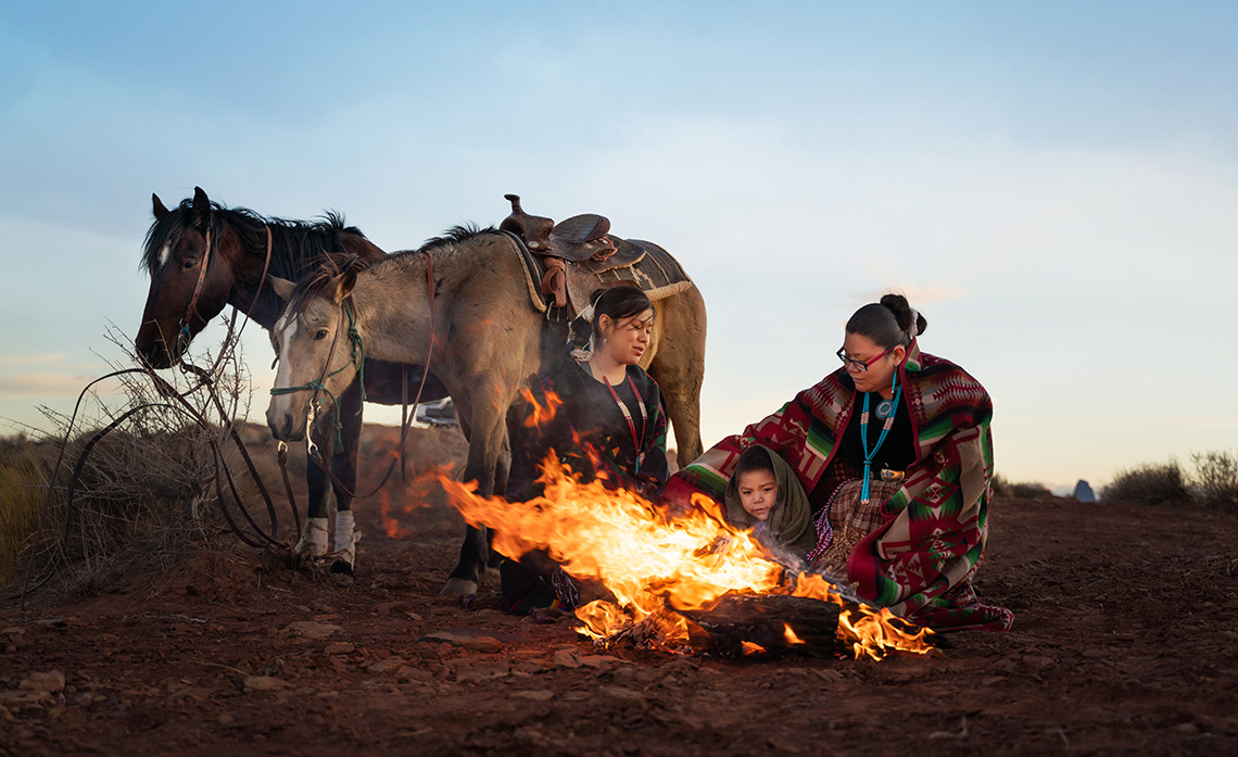 Oral Storytelling A group of people gathered around a fire, telling stories.
