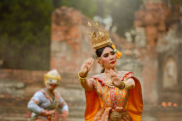 Khon Two dancers in decorated headdresses perform Thai Khon, a classical Thai dance. 1 dancer in the foreground has their arms out, palms facing.