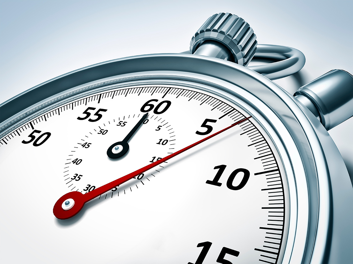 A close-up view of a face of a stop watch, showing the watch hand moving just past the 5 second mark on the right-hand side of the watch.