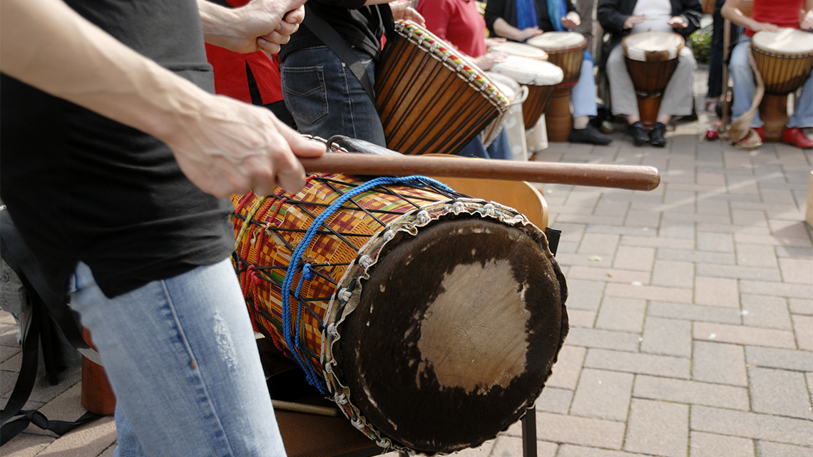 A close-up of drummers performing in a public space.