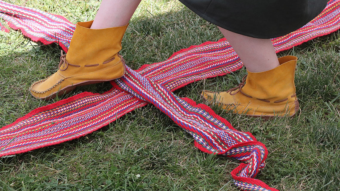 A close-up of a dancer’s feet performing a Sash Dance outdoors.