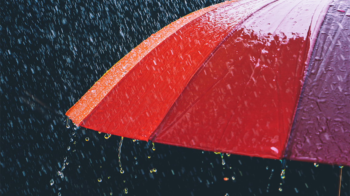 An open umbrella under heavy rain.