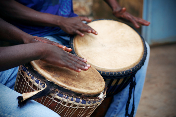 Two musicians playing djembe drums.