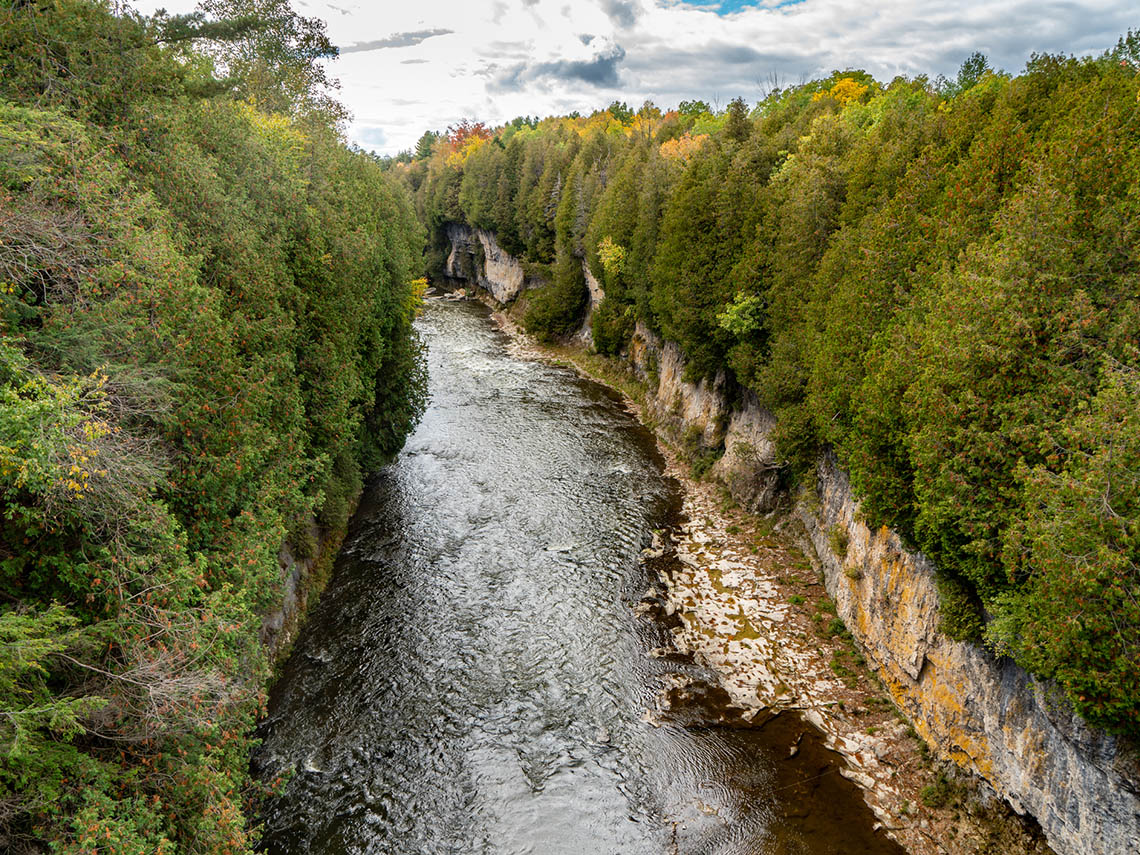  A river with steep, rocky cliffs on each side. There are trees surrounding the river.