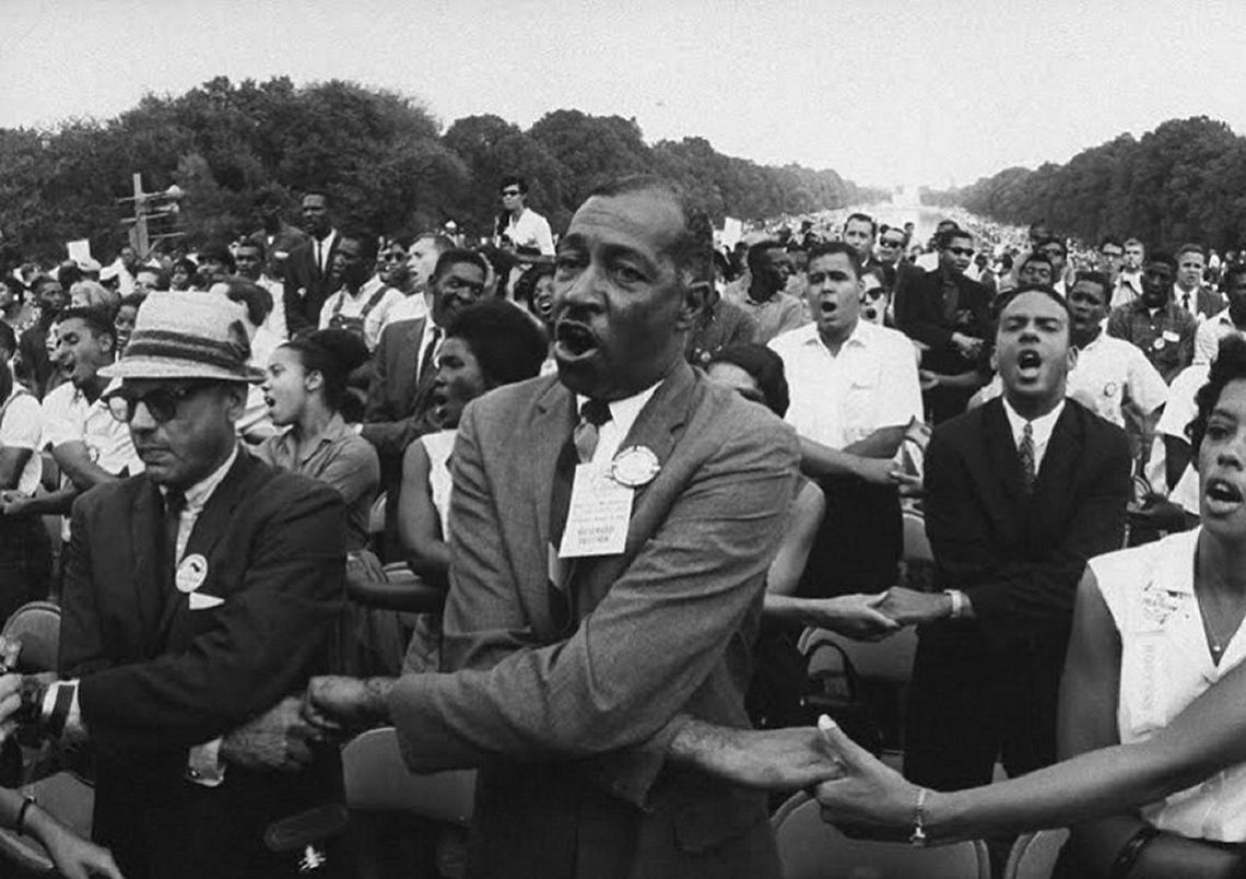 Photo of people holding hands and singing during the Civil Rights Movement in the United States.