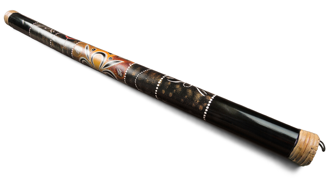 A long wooden instrument that is shaped like a cylinder and painted with a design.