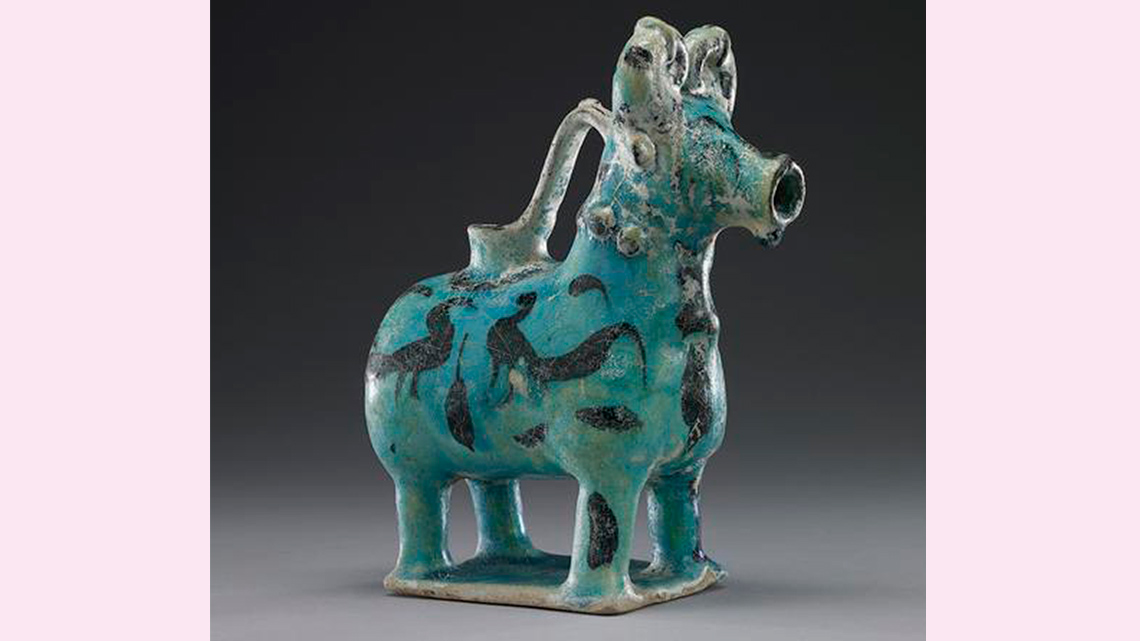 An image of a pitcher made from pottery and shaped like a bull. It could hold water inside.