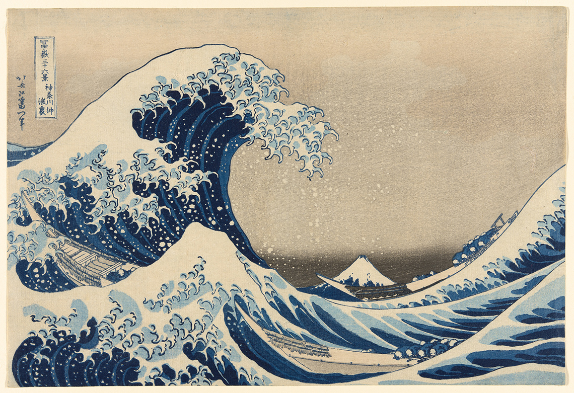 An image of a big wave. The wave is much bigger than the small mountain in the background.