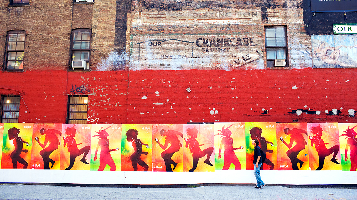 Advertising posters on the side of a building of peoples' silhouettes side by side in a pattern of four different poses.