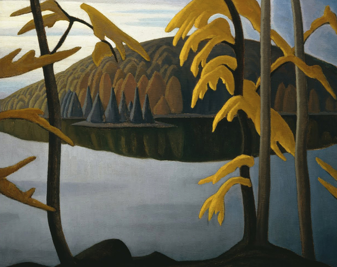 There are four trees with yellow leaves with a lake and small other trees in the background.