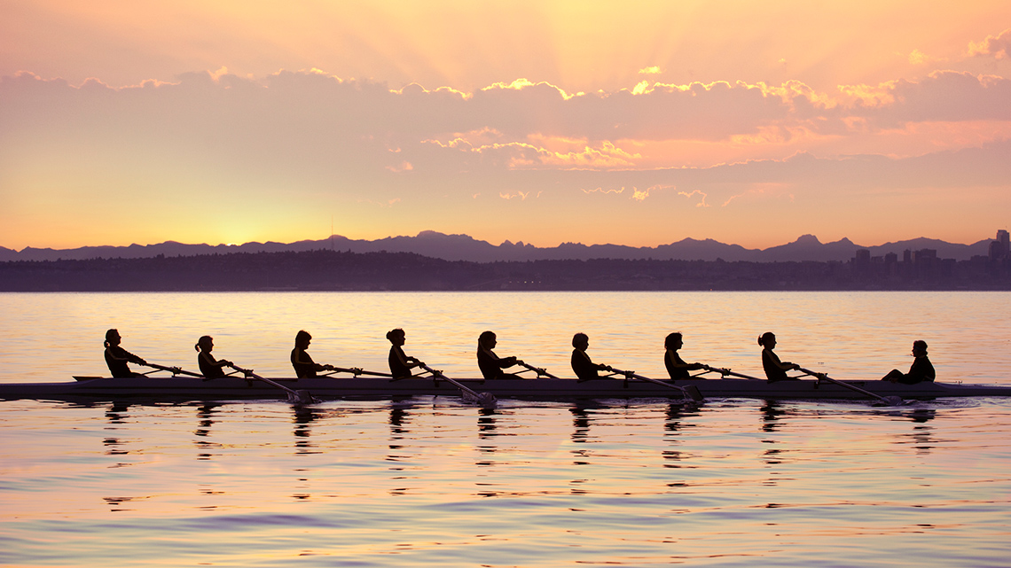 The rowers’ boat forms a horizontal line, and the mountains form a parallel horizontal line where they meet the water.