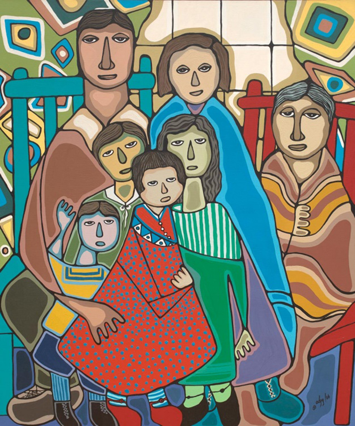 A family of seven people gathered together. Two adults are sitting on chairs, and several children are sitting on the adults’ laps.