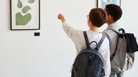 Two people looking closely at a painting in a gallery