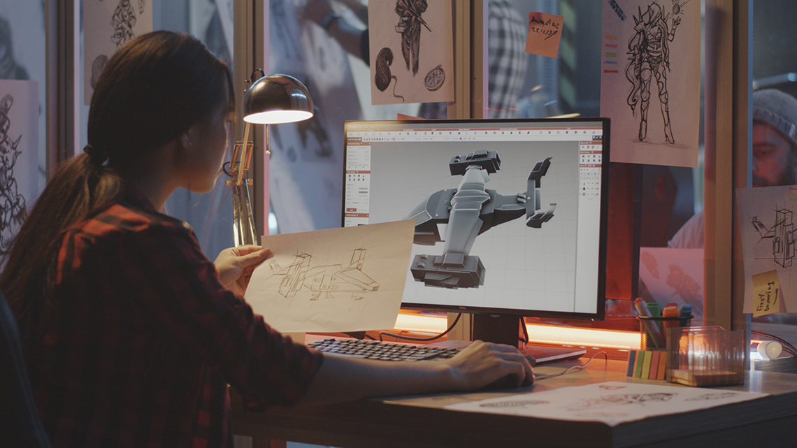 A computer graphics artist comparing a drawing on paper to a three-dimensional model on a computer.