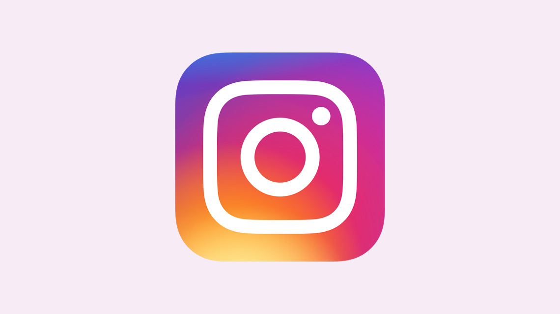 A simple white outline of a camera on a background of purple, pink, orange, and yellow.