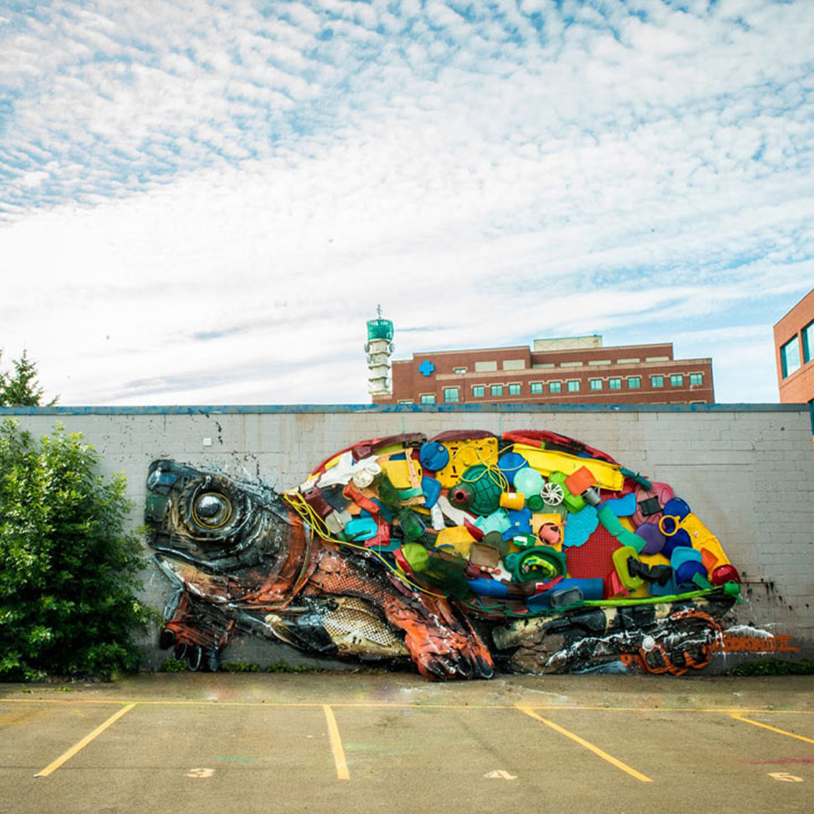 A mural of a turtle on an outdoor parking lot wall.
