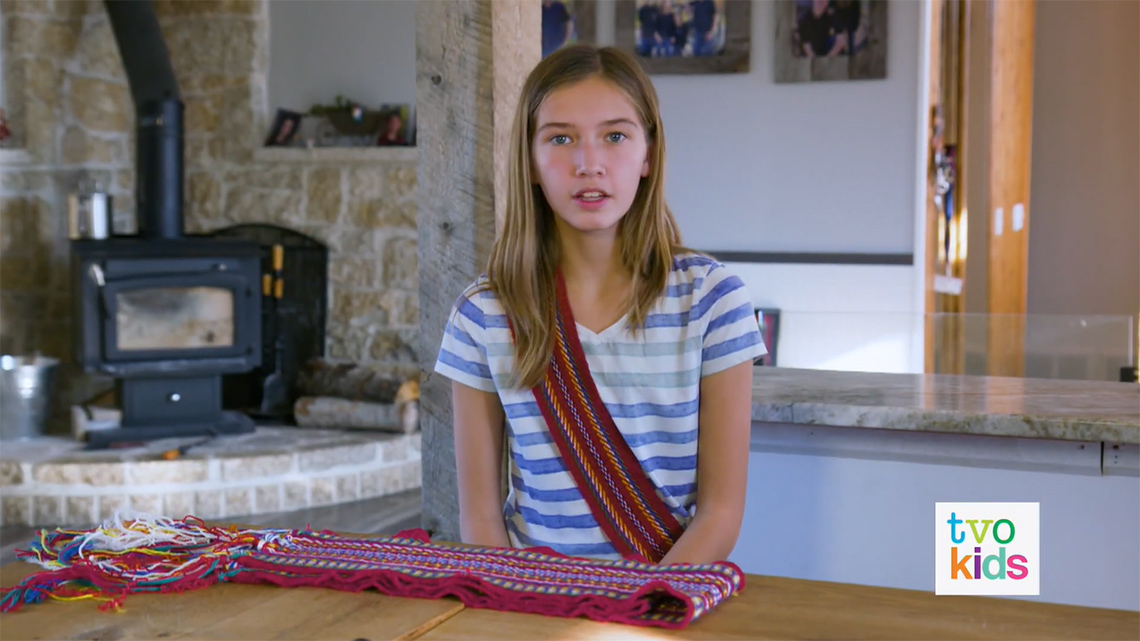 Morgan wearing a Metis sash and also sharing another Metis sash.