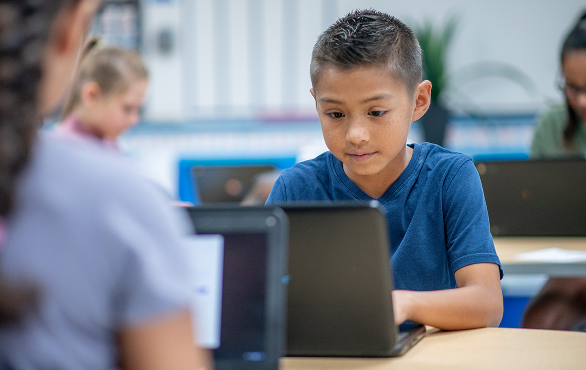 A student working on their laptop in class.