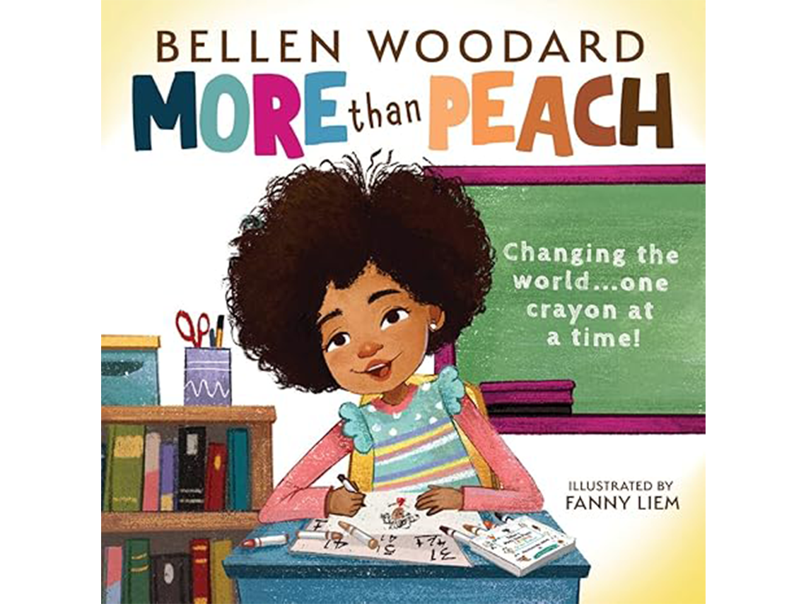the cover of a book titled More than Peach. By Bellen Woodard features a classroom setting with a chalkboard where the phrase Changing the world... one crayon at a time! is written in white. In the center a young black girl with medium brown skin tone and curly brown hair is sitting at a desk, drawing and coloring with crayons.
