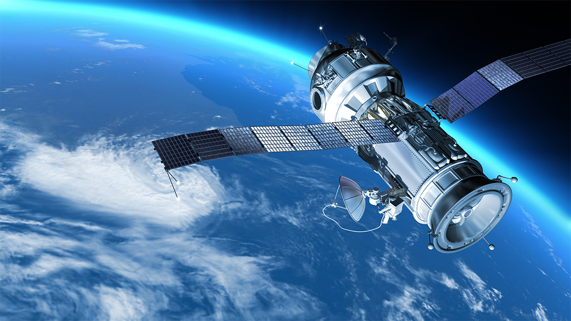 A space satellite with large solar wings floating above a blue planet with large clouds.