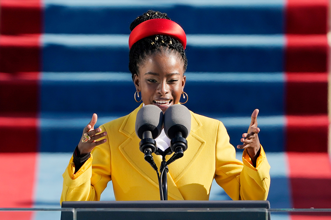 American poet Amanda Gorman behind a podium, speaking into a microphone.