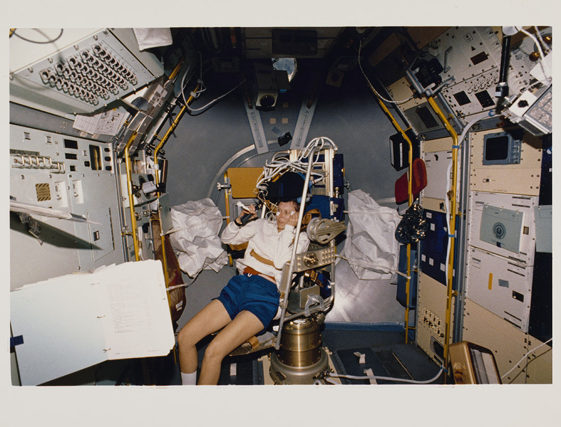 Astronaut experiencing microgravity. A floating book is visible.