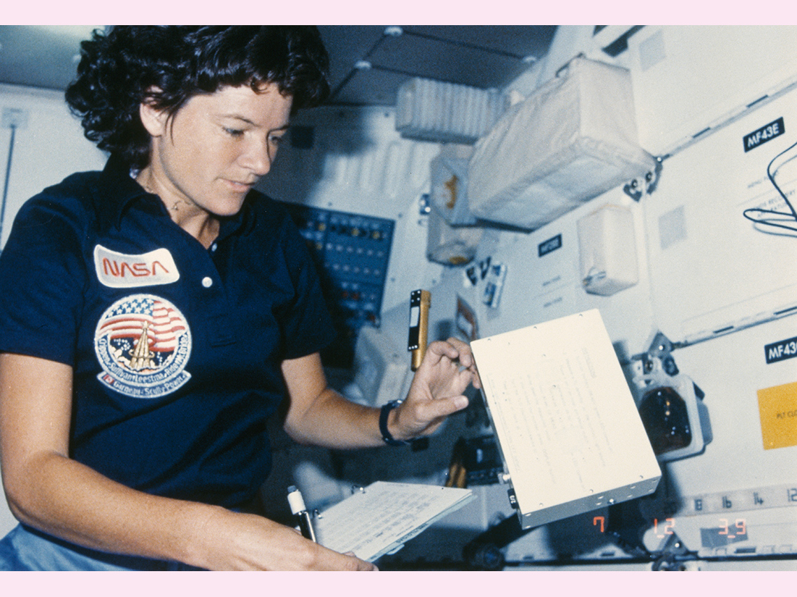 A white female NASA astronaut working in a spacecraft.