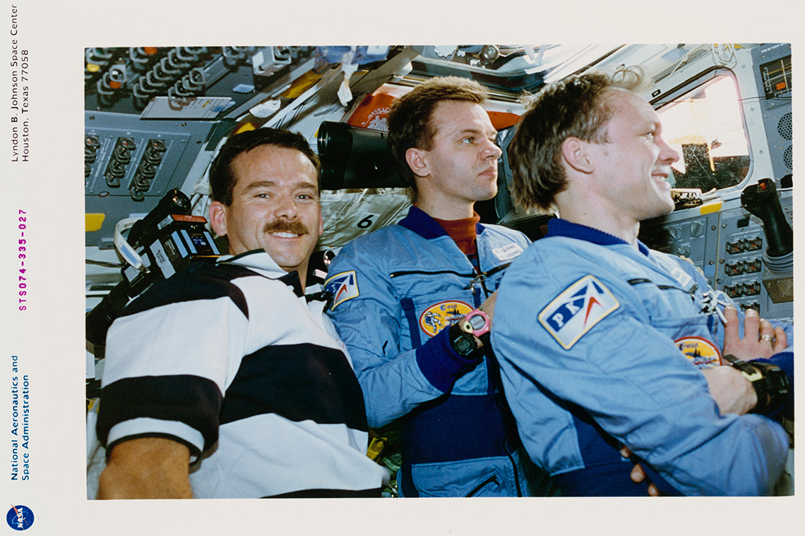 Three professional astronauts in a spacecraft.