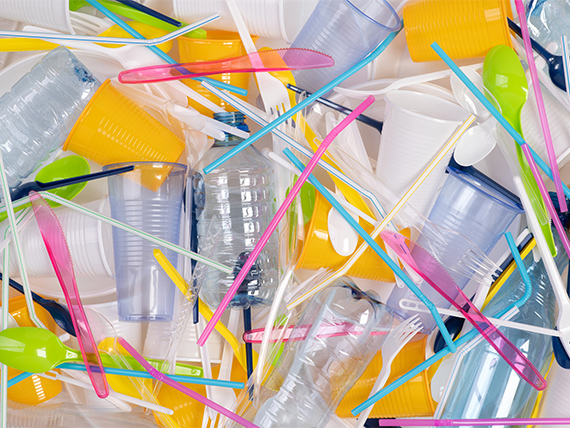 Assorted single-use plastic items including straws, cups, and cutlery